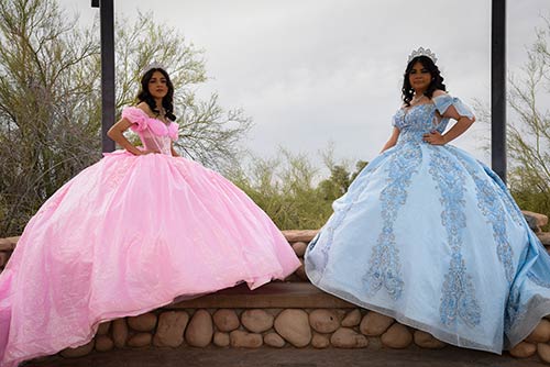 Fotografía profesional de dos quinceañeras en vestidos princesa rosa y azul.